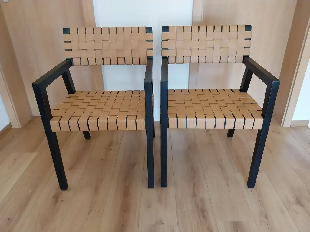 Olivier de SCHRIJVER, (1958), Paire de fauteuils "Boss", bois noirci et lanières de cuir, 53 x 53 x 83 cm, signés et numérotés 15 et 16 /240.